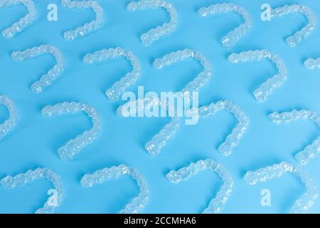 Many invisalign transparent brackets on blue background Stock Photo - Alamy