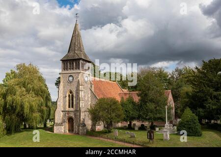 St Nicholas Church in Wickham in Hampshire on a summers day. Heavy skies above the 12th Century building. Stock Photo