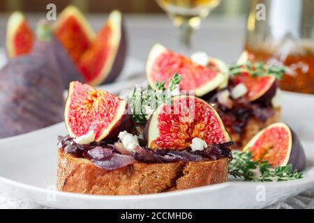 Grain baguette sandwiches with figs, feta cheese, red onion marmalade and thyme . Delicious snack for gourmands. Selective focus Stock Photo