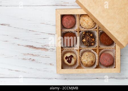 Assorted truffle set  of dark and white chocolate with almonds, hazelnuts and dried cranberries or cherries in a paper box. Candy.  Sweet gift. Holida Stock Photo