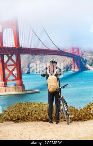 San Francisco Golden Gate Bridge biking tourist with bicycle taking pictures of view on West Coast, California, United States of America. USA travel Stock Photo