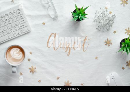 Computer workspace with keyboard, flat lay on white textile. Text Auszeit means Time out in German language. WIntertime desktop, top view with coffee Stock Photo
