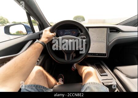 Person driving a new Tesla SUV. The interior of a full-sized, all-electric, luxury, crossover SUV Tesla Model X. Stock Photo