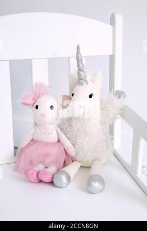Two plush toys sitting on a white rocking chair Stock Photo
