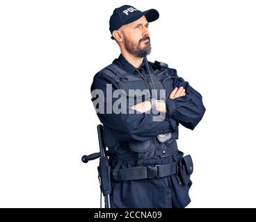 Young handsome man wearing police uniform looking to the side with arms crossed convinced and confident Stock Photo