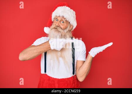 https://l450v.alamy.com/450v/2ccng59/old-senior-man-with-grey-hair-and-long-beard-wearing-white-t-shirt-and-santa-claus-costume-amazed-and-smiling-to-the-camera-while-presenting-with-hand-2ccng59.jpg