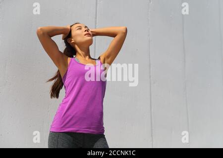 Sweating tired runner girl out of breath wiping off sweat from forehead breathing exhausted dehydrated from heat exhaustion Stock Photo