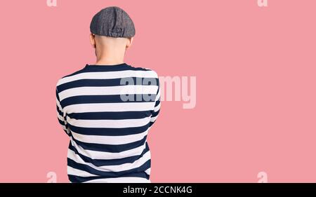 Young handsome man wearing burglar mask standing backwards looking away with crossed arms Stock Photo