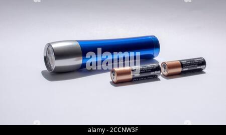 Blue-body flashlight with batteries isolated on white background Stock Photo