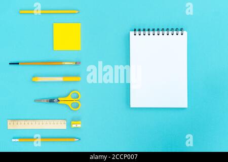 Open a blank notepad on the spiral and office and school supplies on blue background. Copy space, flat lay. Back to school concept. Stock Photo