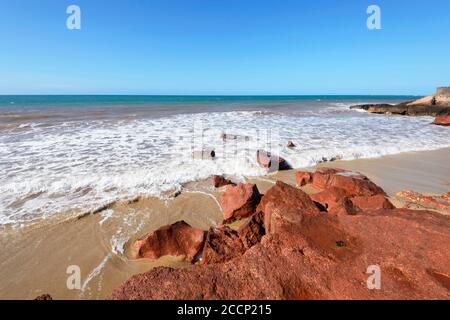 Small waves on a remote colourful beach in Garig Gunak Barlu National Park, Cobourg Peninsula, Arnhem Land, Northern Territory, NT, Australia Stock Photo