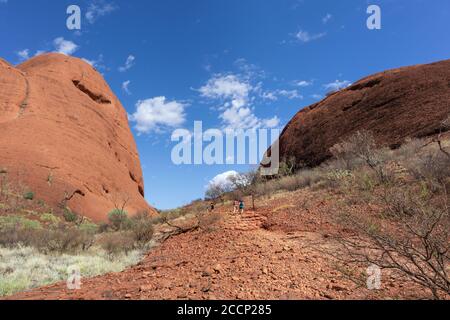 Group of people walking along one of the trekking walks at Valley of the Winds. Tourists between domes. Mount Kata Tjuta - The Olgas, Australia Stock Photo