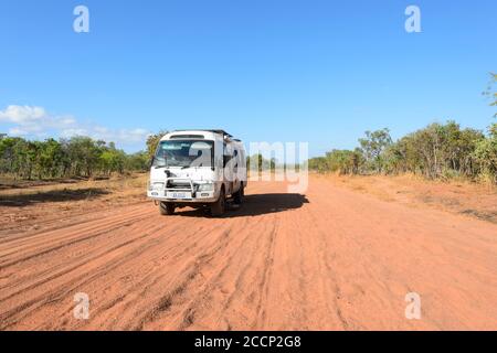 Toyota Coaster minibus motoring on corrugated red dirt road, Cobourg Peninsula, Arnhem Land, Northern Territory, NT, Australia Stock Photo