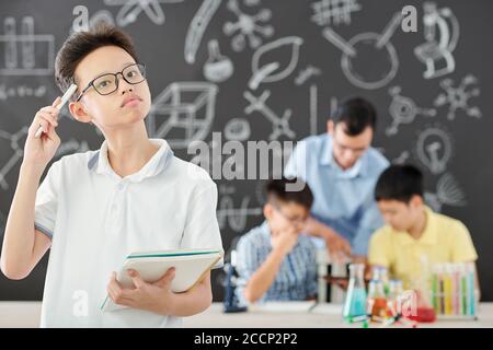 Pensive schoolboy in school laboratory Stock Photo