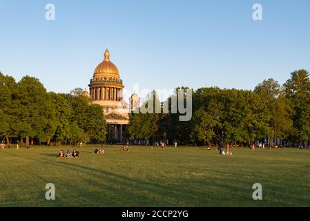 Saint Petersburg, Russia - May 31, 202 Lawn on Senate Square with people resting in front of St. Isaac's Cathedral. Stock Photo