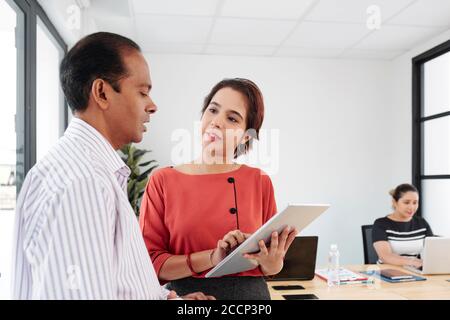 Female entrepreneur talking to colleague Stock Photo