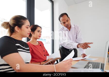 Analyst showing chart on laptop Stock Photo