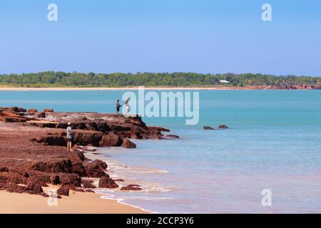 People fishing from the coast. Land based fishing, anglers catching fish (barramundi). Rocky shore. Vivid colors. Dundee Beach near Darwin, Australia Stock Photo