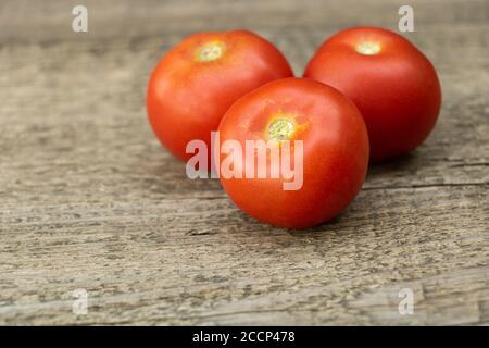 Fresh tomatoes on a wooden background. Tasty tomatoes grown naturally Stock Photo