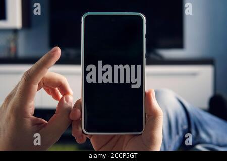 Mockup image blank white screen cell phone.men hand holding texting using mobile at home. background empty space for advertise text. contact business Stock Photo