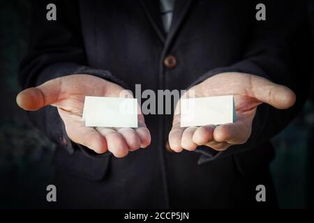 hands is holding a blue color papers with empty space for note. Offer choice of 2 options. Stock Photo