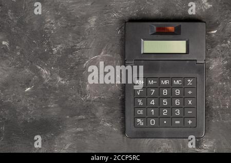 Pocket calculator on dark black background with copy space - tax, finance or accounting concept, top view flat lay from above Stock Photo