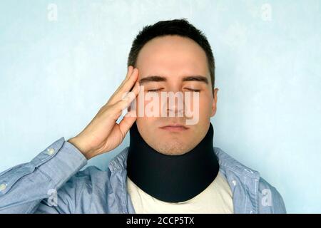 A guy with a bad neck in a black neck collar to stabilize the cervical vertebrae. A man with a neck injury. spinal fracture. headache. Stock Photo