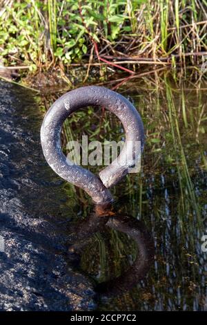 old mooring ring on shore Stock Photo
