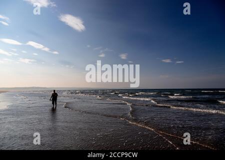 Woman paddling at Llanddona Beach, Anglesey, North Wales Stock Photo