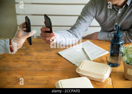 Mature Man and Delivery Person Using E-Payment Stock Photo