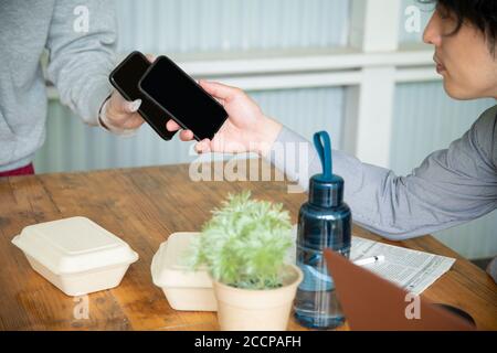 Mature Man and Delivery Person Using E-Payment Stock Photo