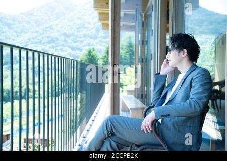 Businessman Talking on the Phone on the Balcony Stock Photo