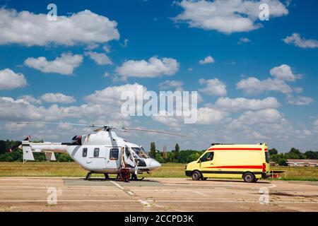A helicopter and an ambulance are on the runway. Transport concept for medical personnel. Stock Photo