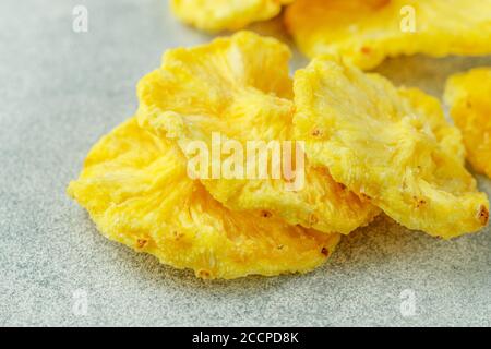 Dried yellow pineapple rings on a grey concrete or stone background. Useful Healthy snack. Selective focus, copy space Stock Photo