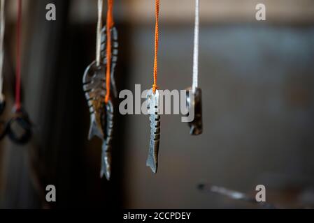 Blacksmith decorative elements hanging at forge, workshop. Handmade, craftsmanship and blacksmithing concept Stock Photo
