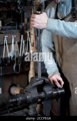 Close-up of a blacksmith's hand working in a smithy with his tools Stock Photo