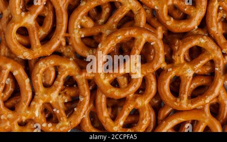 Mini pretzels with salt close-up. Traditional German beer appetizer. Culinary background. Selective focus, top view Stock Photo