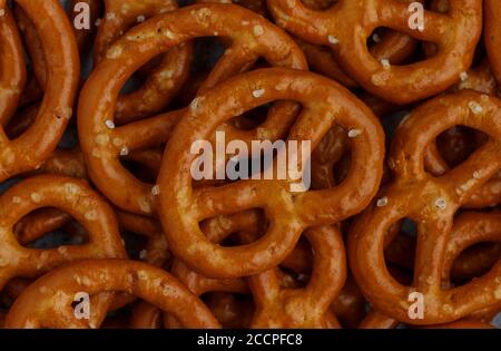 Mini pretzels with salt close-up. Traditional German beer appetizer. Culinary background. Selective focus, top view Stock Photo
