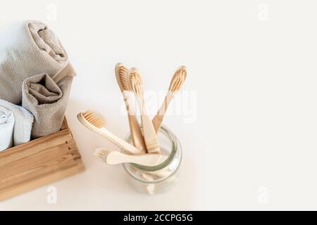 Composition with biodegradable bamboo toothbrushes and linen towels on marble background. Sustainable, zero waste, plastic free, lifestyle concept. Flat lay, top view. Stock Photo