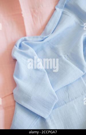 Beautiful blue muslin fabric on a pink background, top view Stock Photo