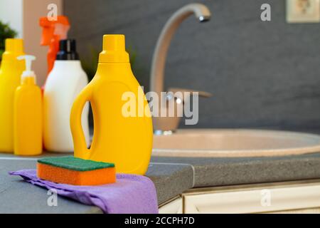 Household chemicals product bottles standing near the kitchen sink Stock Photo