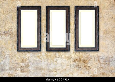 Three vintage wooden empty picture frames on old stucco wall. Retro blank frame on room wall. Mock up template. Copy space for text Stock Photo