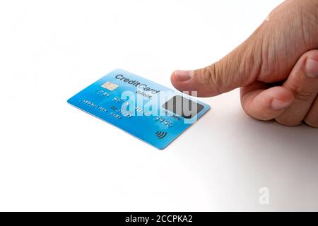Isolated credit card and male finger touching biometric sensor. Biometric verification on credit card. User must have finger over the sensor when Stock Photo