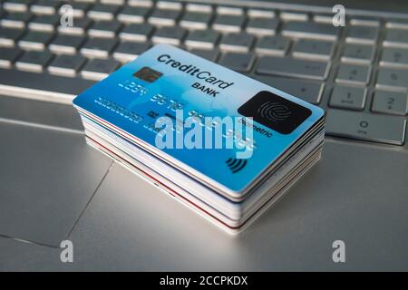 Pile of plastic credit cards on the laptop keyboard. Open access for online shopping using biometric card. Payment cards with finger sensor on the Stock Photo