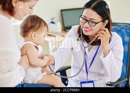 Doctor listening to breath of girl Stock Photo
