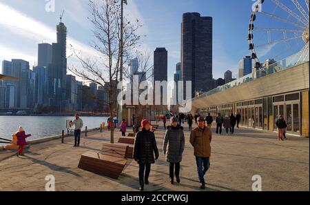 Walking along Navy pier with Chicago city skyline and Centennial Wheel in the background, Chicago Illinois, United States Stock Photo