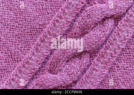 Openwork pattern knitted with needles from pink wool yarn. Stock Photo