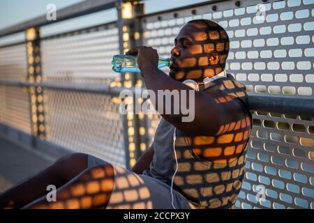 Young african-american man is exercising on the bridge in the city. Stock Photo
