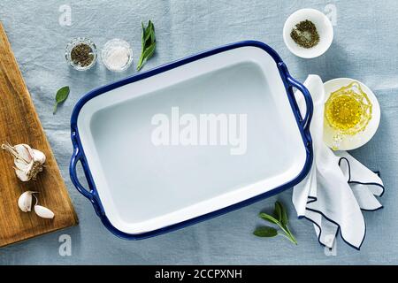 table setting with empty ceramic baking dish on a blue linen tablecloth Stock Photo