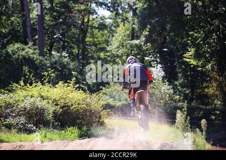 Motocrosser at the jump photographed from behind Stock Photo